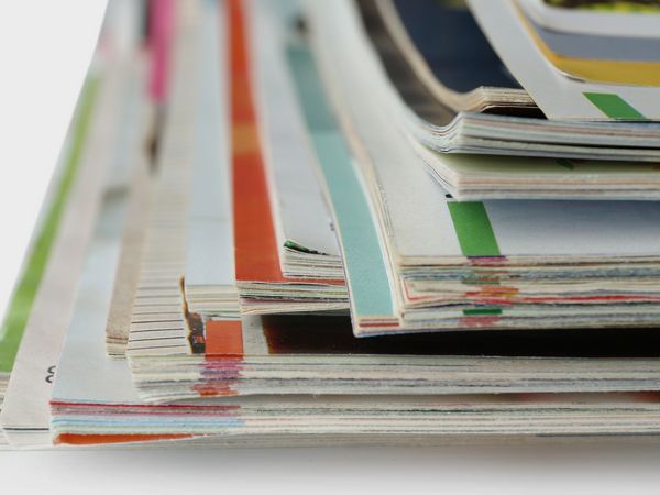Stapel aus Zeitschriften und Broschüren auf einem Tisch. Das Bild verweist auf die Dienstleistungen des Fleischerhandwerks.